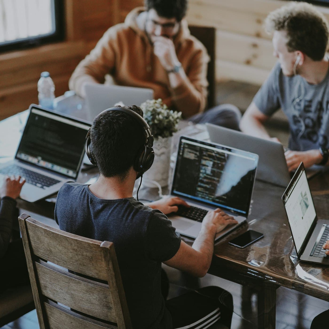 Developers collaborating around laptops in a studio